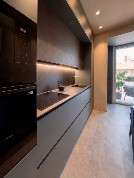 Cucina contemporanea su misura con finiture materiche e gola nera